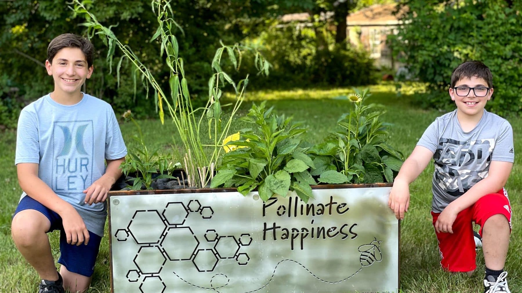 Aidan and Ben Ellis kneeling beside their first planter bench at Wawapek Preserve, June 2021
